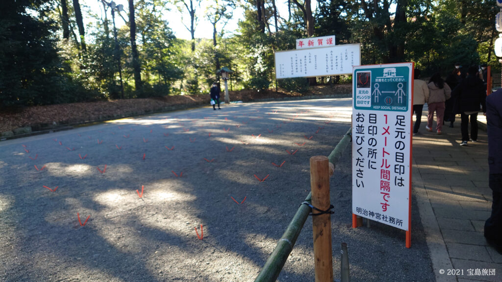 赤いプラスチックの紐のようなものを1メートル間隔で参道に打ち込んでいました。