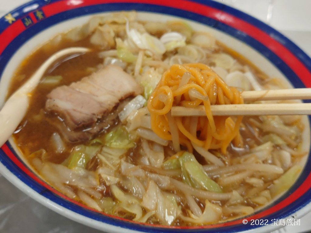 山食の若き血味噌ラーメンのめんあげの写真です。唐辛子を混ぜた麺の色はオレンジに変わった状態です。